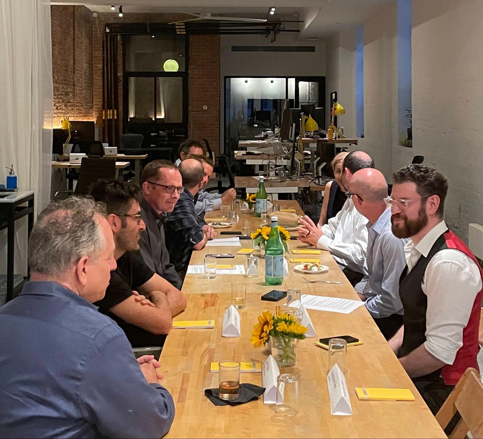 Attendees seated around the long table at the Synology conversation at the Macktez office