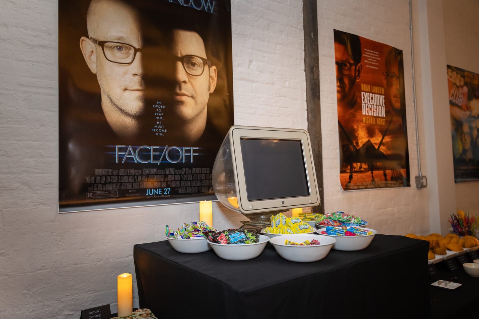 Bowls of candy in front of a vintage Apple CRT Studio Display and movie posters spoofing Face/Off and Executive Decision, starring Noah Landow and Michael Horst