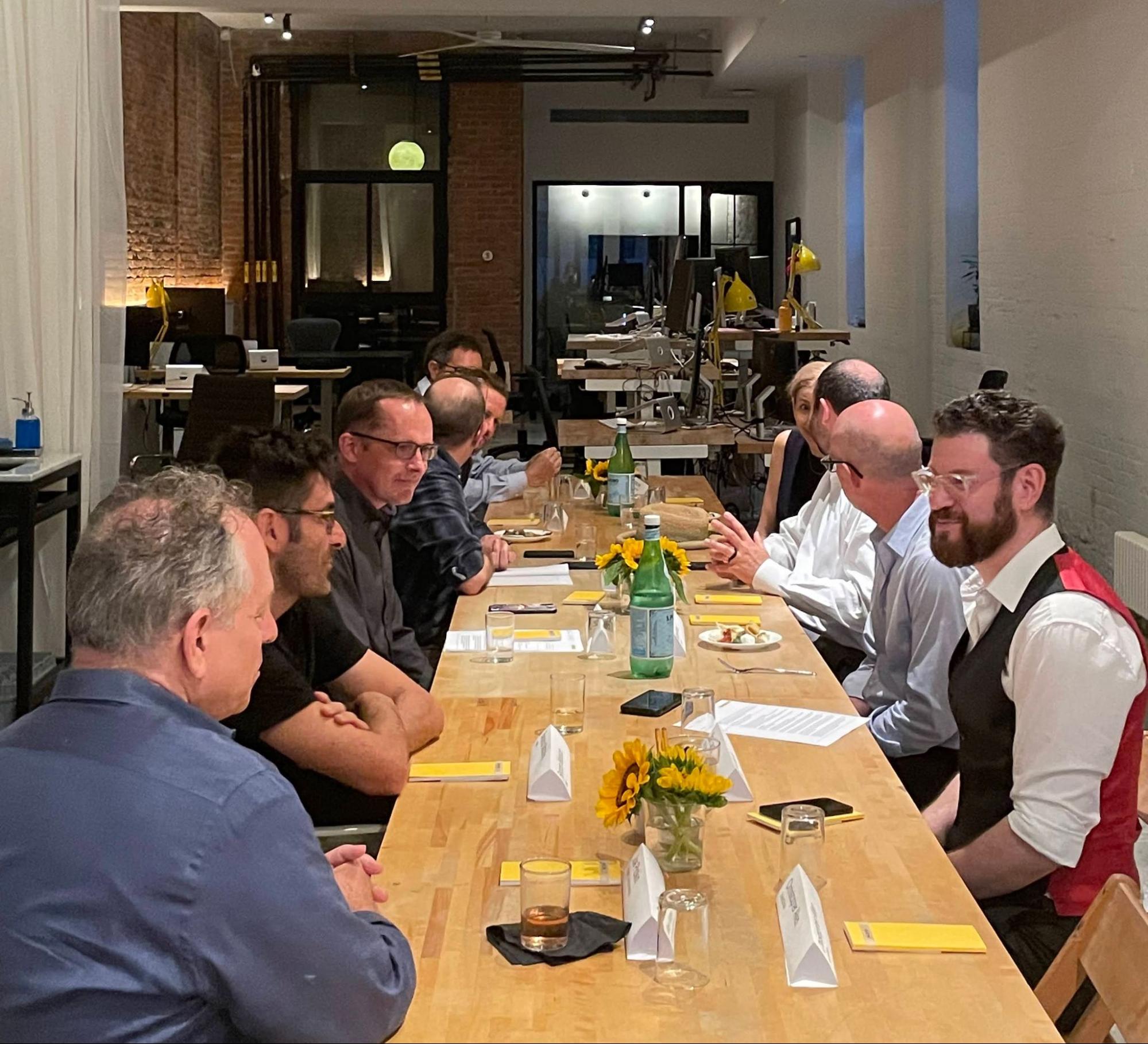 Attendees seated around the long table at the Synology conversation at the Macktez office