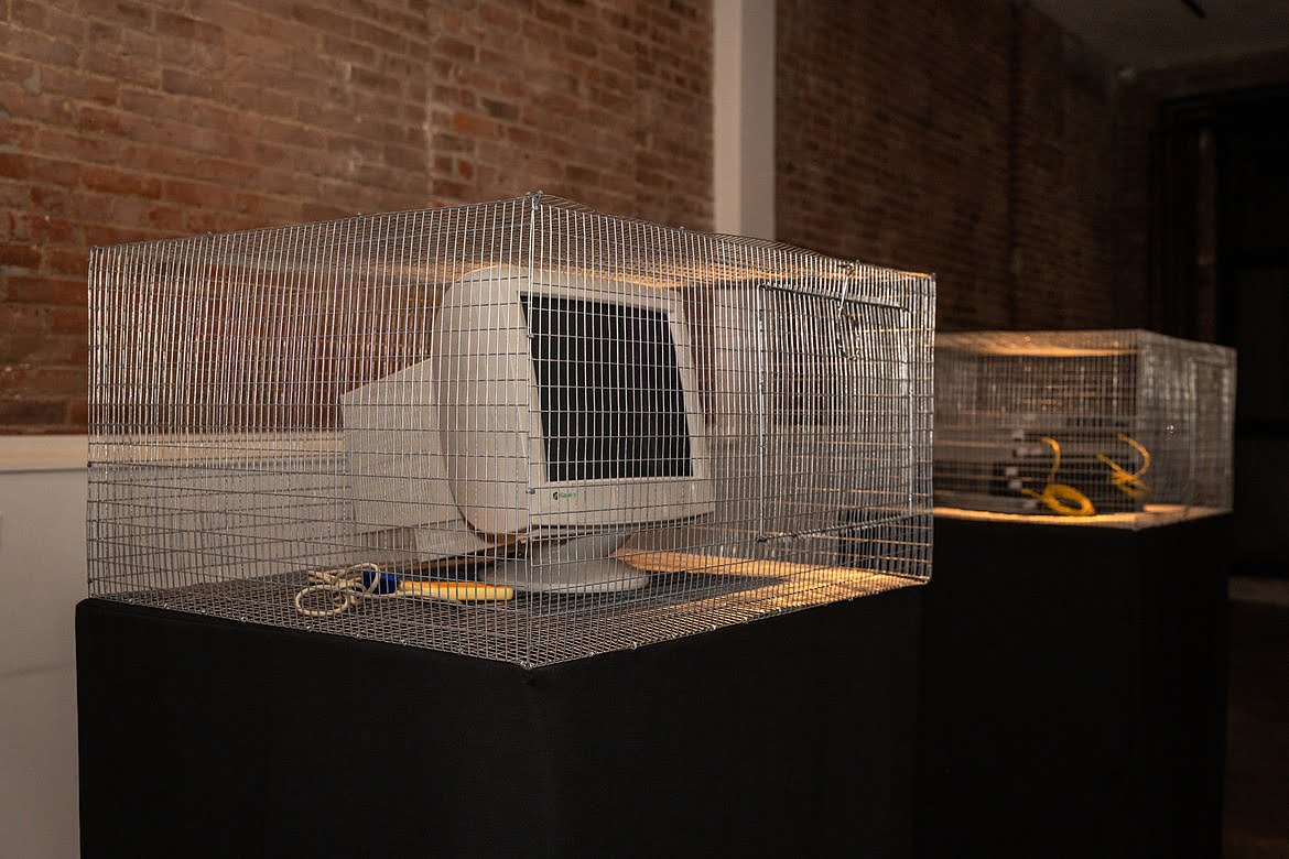 Two wire cage pedestals in the Macktez office, one holding a CRT monitor, part of the tech beast installation