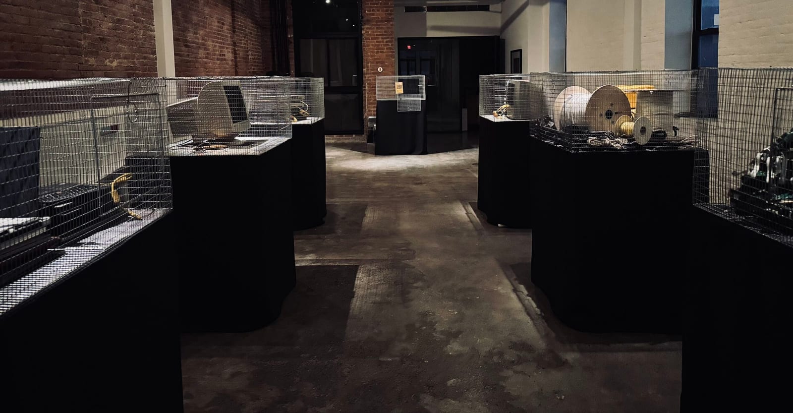 Wide view of the Macktez office showing wire cages on black pedestals as part of the tech beast installation