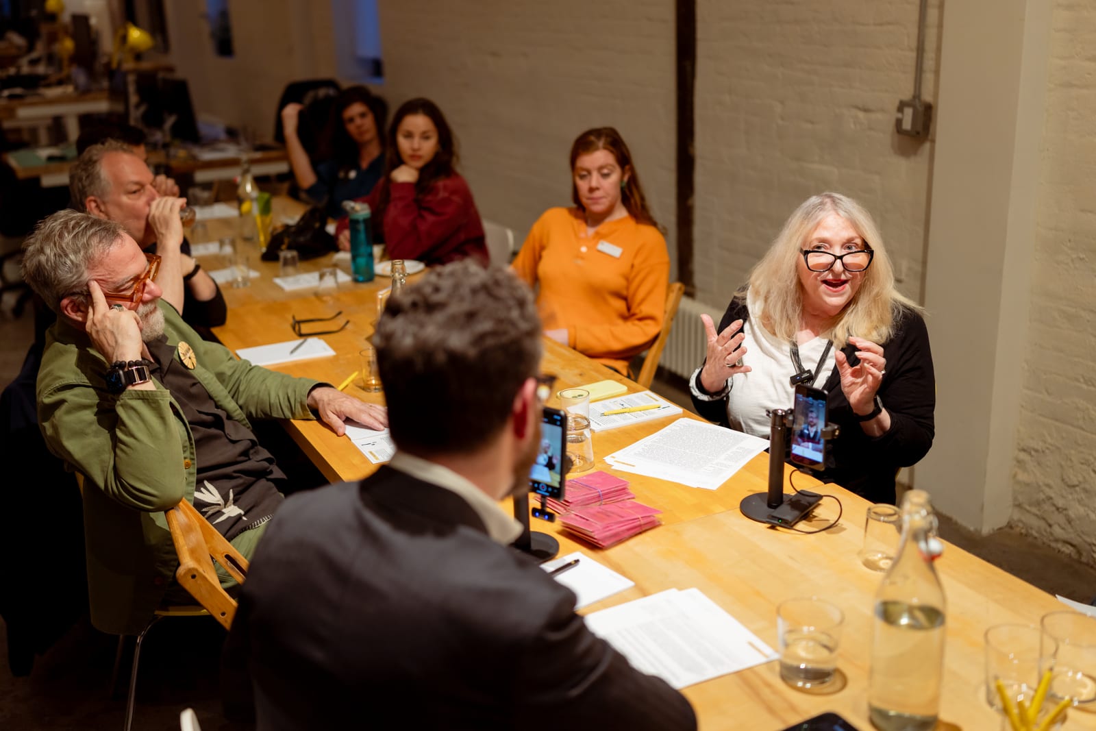 Ruby Lerner speaking to attendees seated around the table at the Tête-à-Tech event